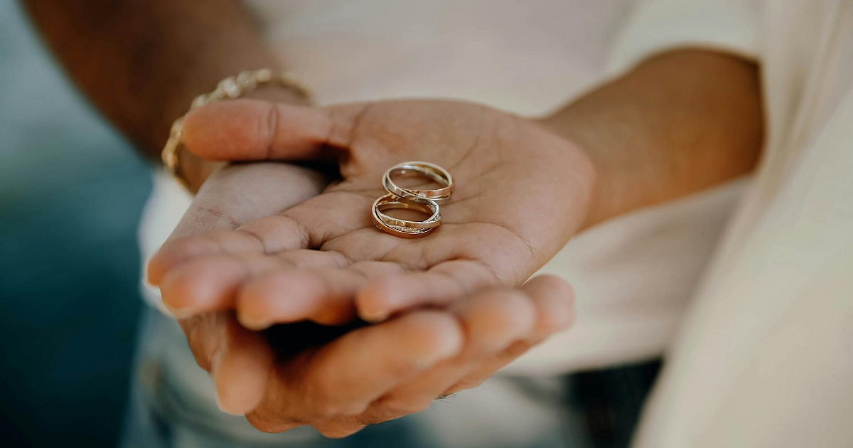 手のひらに二つの結婚指輪を載せている写真