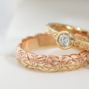 ハワイアンジュエリーMaxiの結婚指輪と婚約指輪を重ねて置いている写真