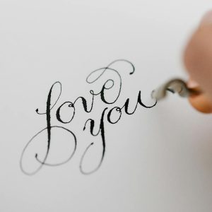 「Lovy you」と万年筆でレタリングしている写真