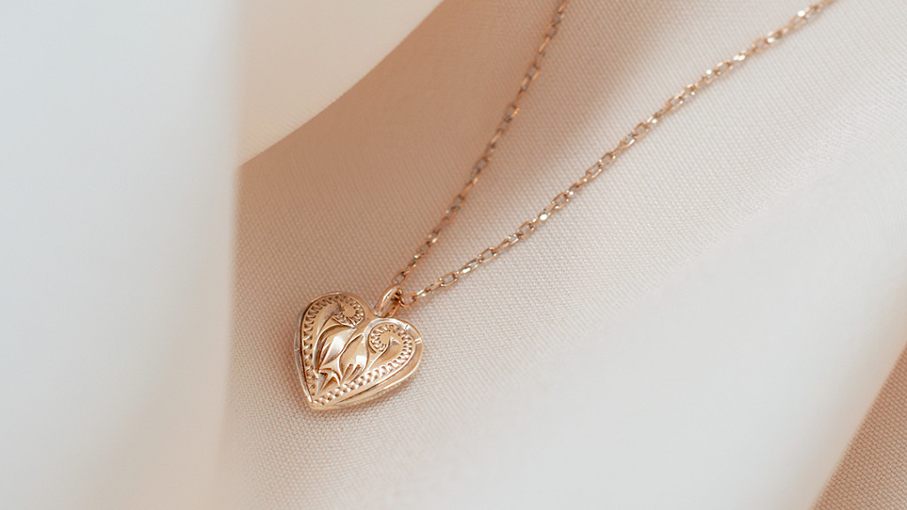 繊細な手彫り模様が施されたハート型トップを持つ、MaxiのK10イエローゴールド製ハワイアンジュエリーネックレス