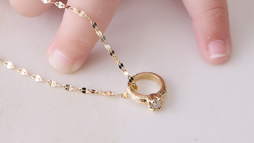 赤ちゃんの指と、Maxiのダイヤモンドがセットされたソリッドタイプのハワイアンジュエリーベビーリング。健やかな成長を願う一生のお守りを象徴するイメージ。